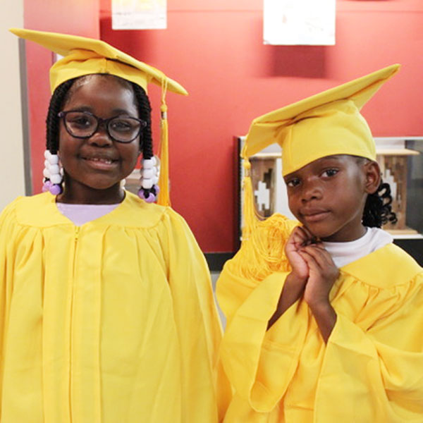 Two young children in yellow graduation gowns